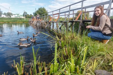 Ördekler Suzdal içinde ahşap bir köprüde besleme kız