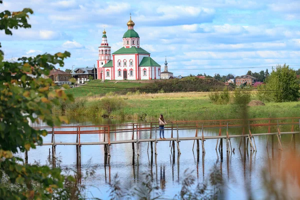 Dziewczyna na drewniany most w Suzdal w tle Kościół El — Zdjęcie stockowe