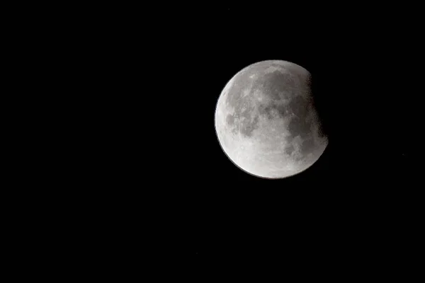 暗い夜空に美しく見える満月は その一部を覆う雲から逃げているようです — ストック写真