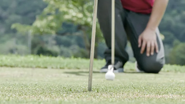 Golf ball och putter på grönt gräs ju — Stockfoto