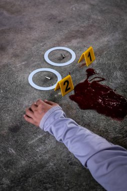 Adli tıp müfettişi olay yerindeki bir silahın fişeklerini vurguluyor. 