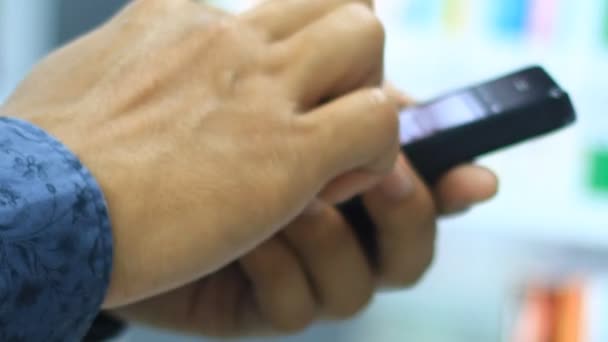 Un hombre usa su smartphone en la librería — Vídeo de stock