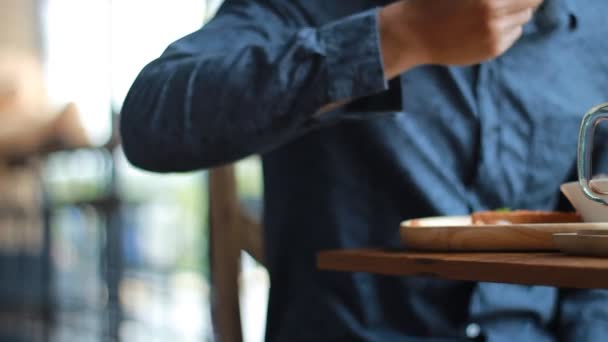 Hombre joven con Tablet PC beber café en la cafetería — Vídeos de Stock