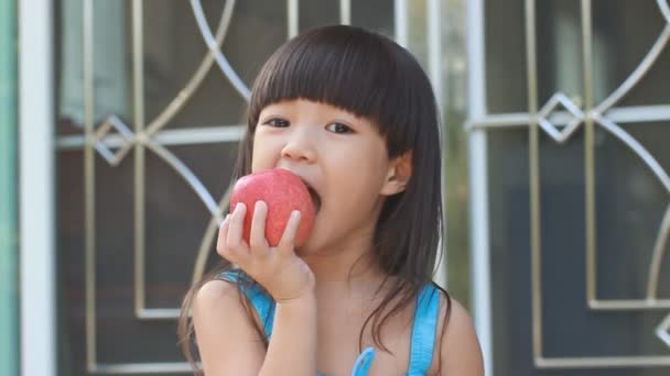 Девушка ест яблоко — стоковое видео