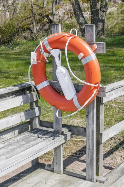 Reddingsboei op een rustieke houten steiger — Stockfoto