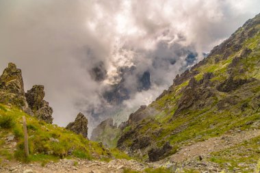 Slovakya, Yüksek Tatras - Dağ manzarası, kayalık dağlar ve iki dağ yamacı arasında bir vadi, vadi boyunca hareket eden bulutlar