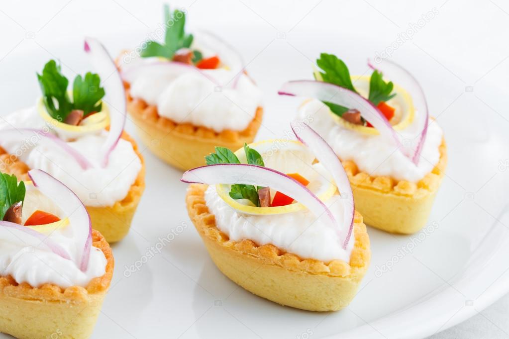 Salty mini tartlets stuffed with cream cheese and  vegetable
