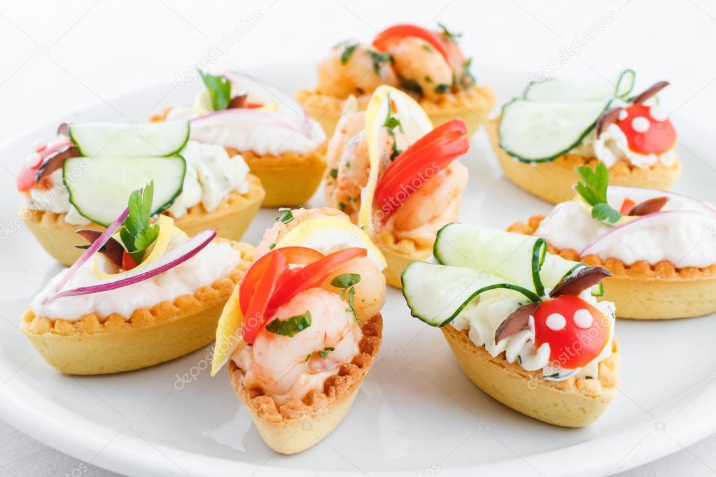 Assortment of salty mini tartlets stuffed with vegetable, shrimps and cream cheese