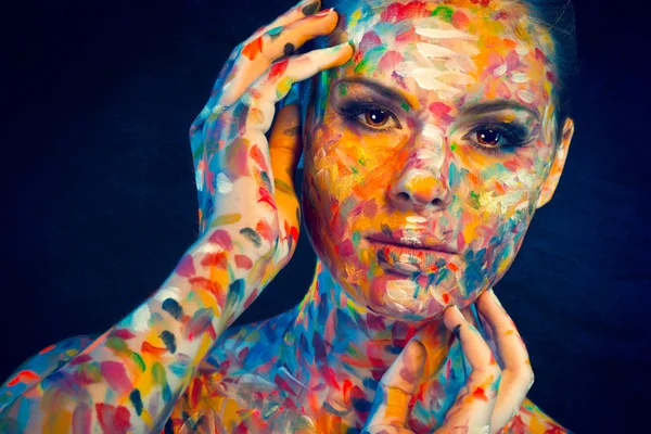 Schönes Frauengesicht mit bunter Farbe bedeckt — Stockfoto