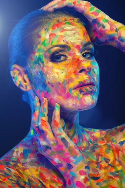 Beautiful woman's face covered with colorful paint — Stock Photo, Image