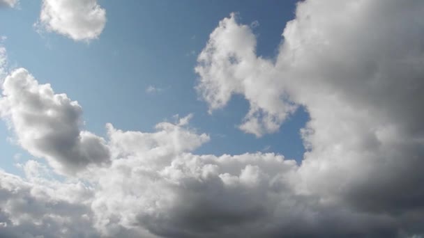 Časosběrné záběry bílé a nějaké temné mraky, pohybující se po modré obloze — Stock video