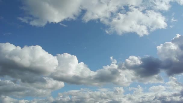 Poklatkowy zdjęcia białe i niektórych ciemnych chmur przemieszczających się między błękitne niebo — Wideo stockowe