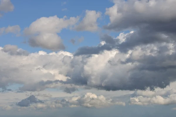 Branco e algumas nuvens escuras no céu — Fotografia de Stock