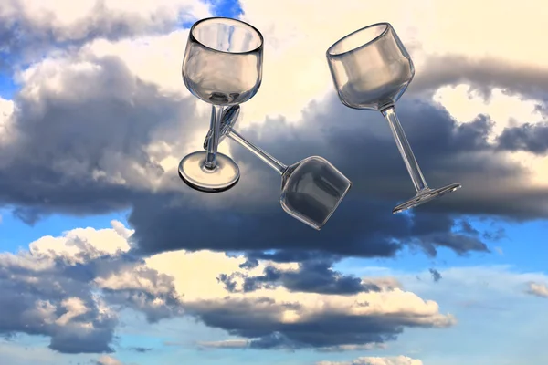 Lege wijnglazen en een echte wereld foto van een bewolkte hemel — Stockfoto