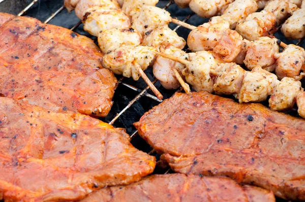 Stevige barbecuepinnen en grill steaks op een grill — Stockfoto