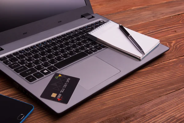 Concetto di shopping online laptop, tablet pc, blocco note, penna e carta di credito su sfondo rustico in legno — Foto Stock