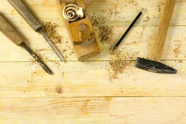 Timmerman tools op houten tafel met zaagsel. Craftperson werkplek bovenaanzicht — Stockfoto