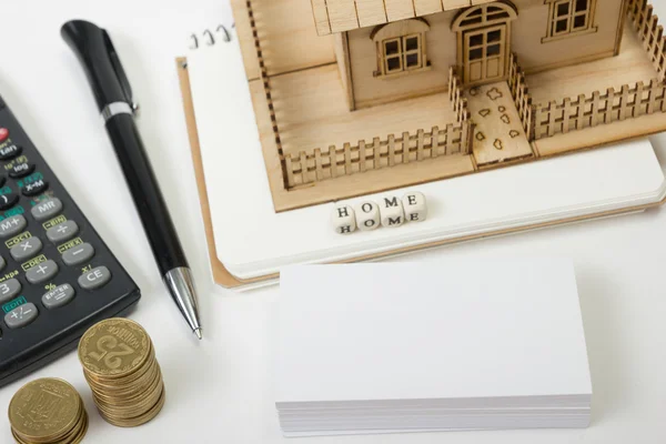 Concept of housing purchase and insurance. Office desk table with supplies top view. Calculator. golden coins, pen, notepad, green model house, wooden block word — Stock Photo, Image