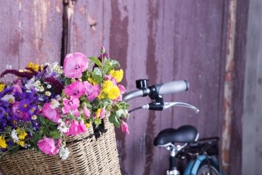 Vintage Bisiklet ve çiçeklerle şehir arka planda açık güneş ışığı üzerinde mutlu güzel bir genç kız portresi. Etkin boş kavramı.
