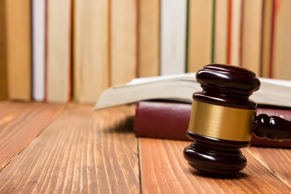 Boek van de wet met houten rechters hamer op tafel in een rechtszaal of wet tenuitvoerleggingsdienst. — Stockfoto