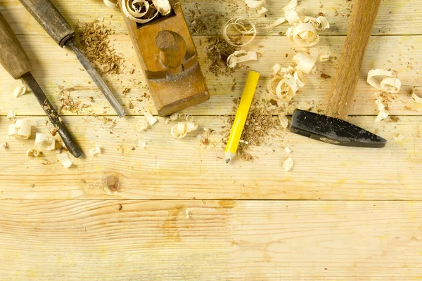 Tesař nástroje na dřevěný stůl s pilinami. Craftperson pracoviště: pohled shora — Stock fotografie