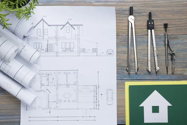 Concepto de bienes raíces. Proyecto arquitectónico, planos, rollos planos y brújula divisoria en mesa de madera vintage. Vista superior. Fondo de construcción. Herramientas de ingeniería. Arquitecto lugar de trabajo . — Foto de Stock