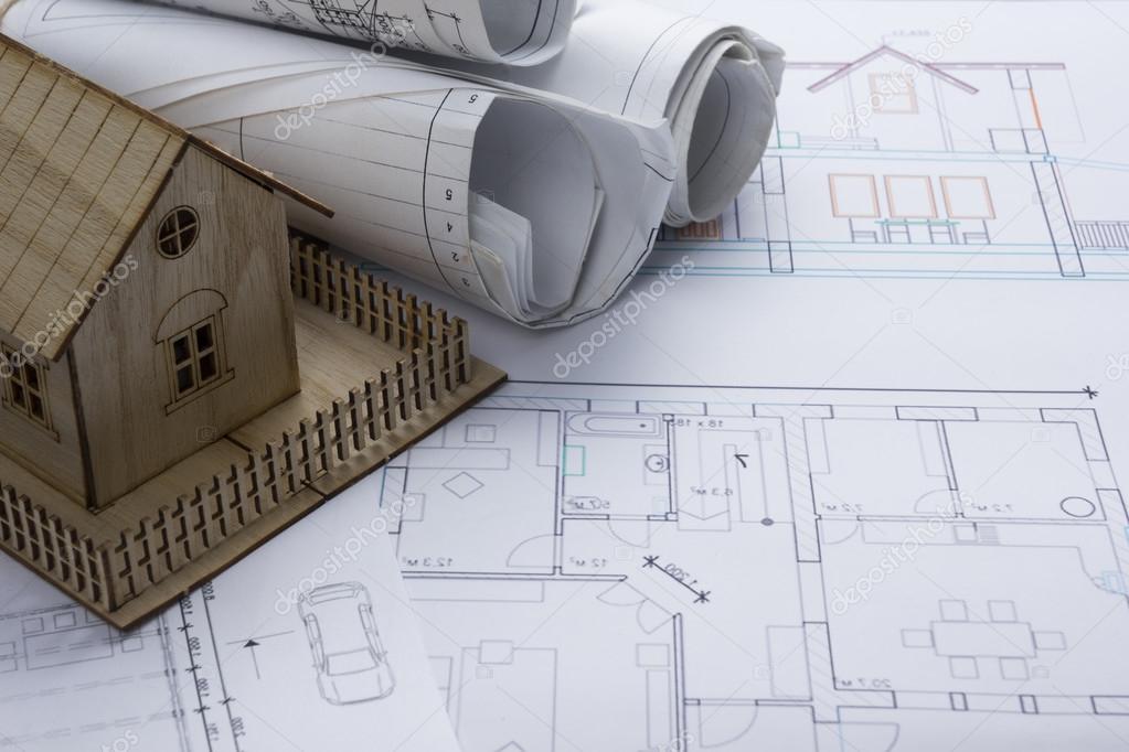 Real Estate concept. Architect workplace. Architectural project, blueprints, blueprint rolls and  model house on plans. Top view. Construction background. Engineering tools.
