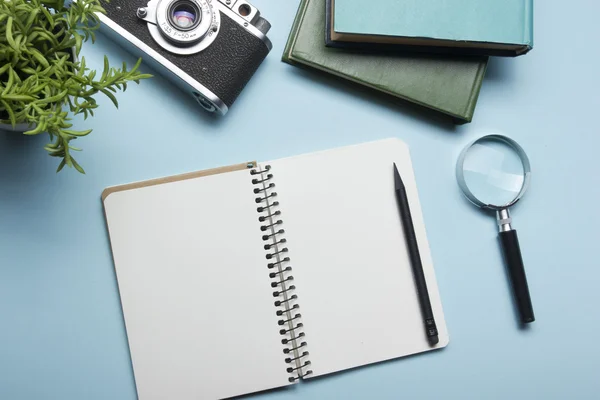 Tourism, travel concept. Office desk table with notepad, camera and supplies. Top view. Copy space for text.