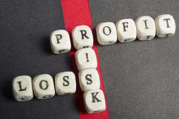 Profit, loss and risk crossword blocks on table. Top view — Stock Photo, Image