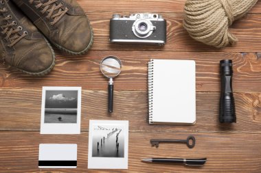 Seyahat, tatil kavramı. Fotoğraf makinesi, not defteri, kalem, kredi kartı, malzemeleri ve fotoğraf üzerinde ofis ahşap resepsiyon masası. Metin kopyalama yeri olan Üstten Görünüm