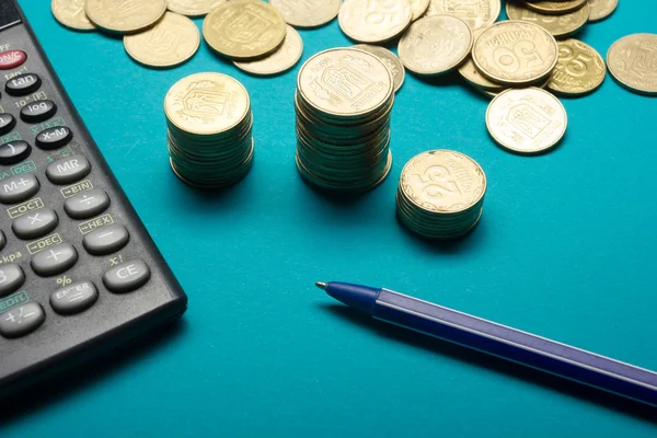 Caneta, pilha de moedas de dinheiro e calculadora para o conceito de finanças — Fotografia de Stock