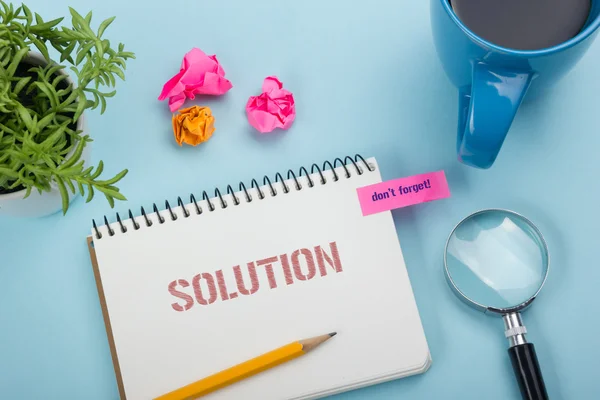 Solución. Bloc de notas con mensaje, lápiz, taza de café y flor. Materiales de oficina en mesa de escritorio vista superior . — Foto de Stock