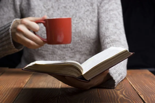 책을 읽고, 차 또는 커피 잔을 들고 젊은 여자. 몸매 이미지 — 스톡 사진