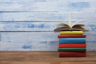 Açık kitap, ahşap masadaki ciltli kitaplar. Okula dönelim. Boşluğu kopyala