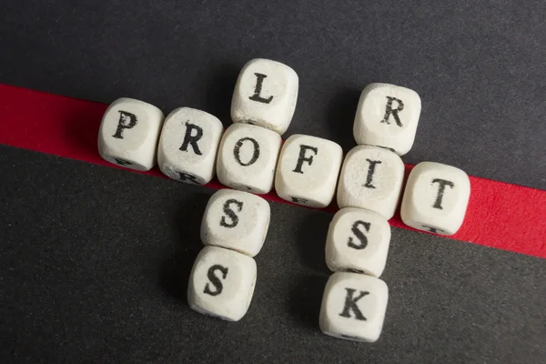 Profit, loss and risk crossword blocks on table. Top view — Stock Photo, Image