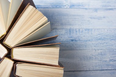 Açık kitap, ahşap masadaki ciltli kitaplar. Okula dönelim. Metin için alanı kopyala