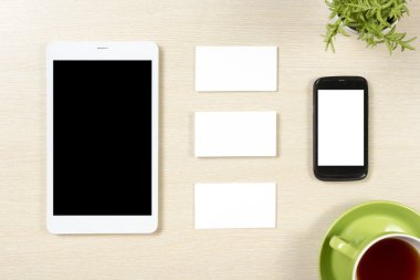 İş kartı boş, akıllı telefon veya tablet pc, çiçek ve kahve Kupası'nda office Resepsiyon Masa üstten görünüm. Kurumsal ileti örneği marka model