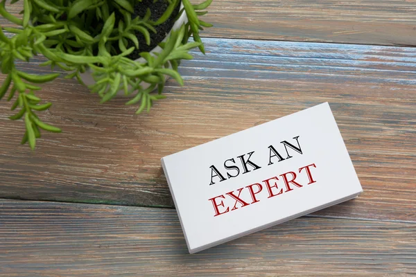 Vraag een expert. Visitekaartje met bericht. Kantoorbenodigdheden op Bureau tafel bovenaanzicht. — Stockfoto