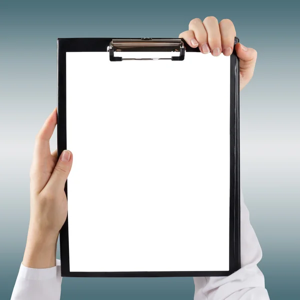 Female doctor's hand holding medical clipboard with blank sheet of paper blurred background. Concept of Healthcare And Medicine. Copy space. — Stockfoto
