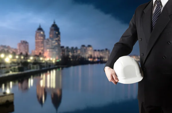 Primer plano de la mano del ingeniero sosteniendo casco de seguridad blanco para el trabajador — Foto de Stock
