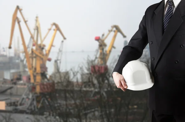 Primer plano de la mano del ingeniero sosteniendo casco de seguridad blanco para el trabajador — Foto de Stock