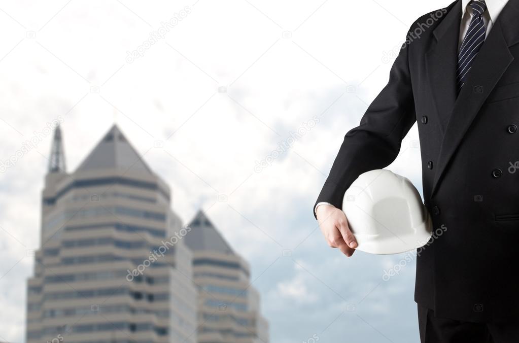 Close up of engineer hand holding white safety helmet for worker