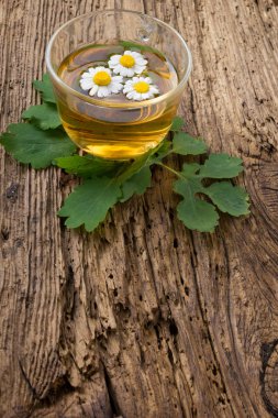 Eski ahşap masa üzerinde papatya bitkisel çay. Üstten Görünüm. Alternatif Tıp kavramı