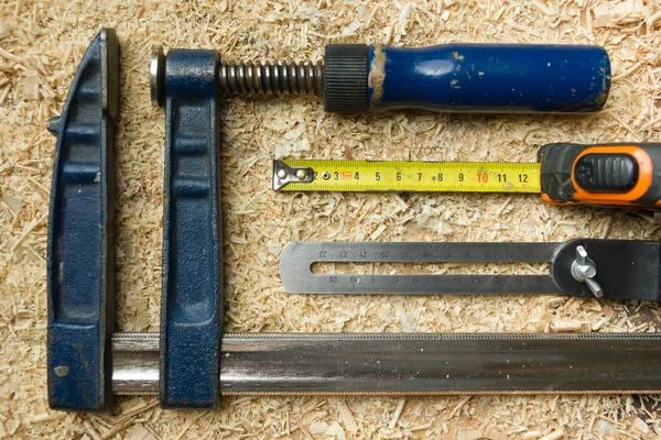 Herramientas de carpintería sobre mesa de madera con serrín. Carpintero lugar de trabajo vista superior —  Fotos de Stock
