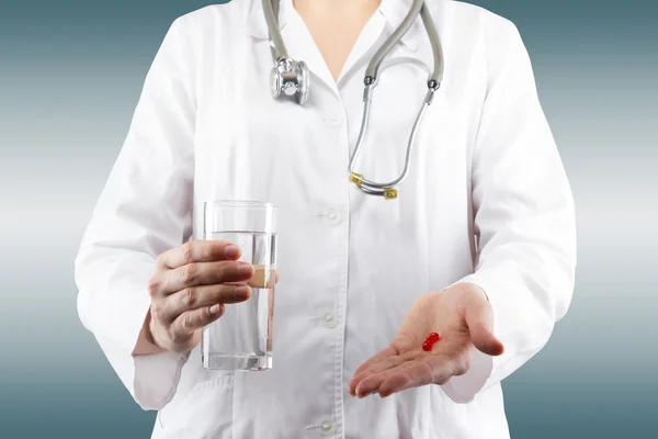 Main de femme médecin tenant un verre d'eau, donnant des pilules. Fermer — Photo