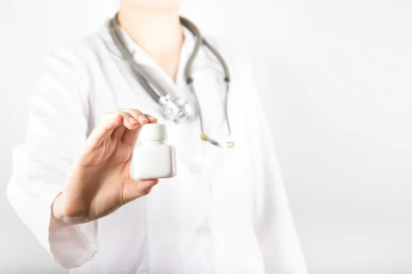 Ärztin hält eine Flasche Tabletten oder Pillen in die Höhe — Stockfoto
