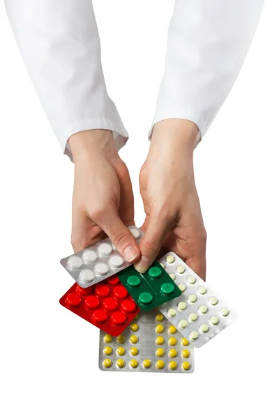 Mão do médico feminino segurando pílulas médicas isoladas em branco — Fotografia de Stock