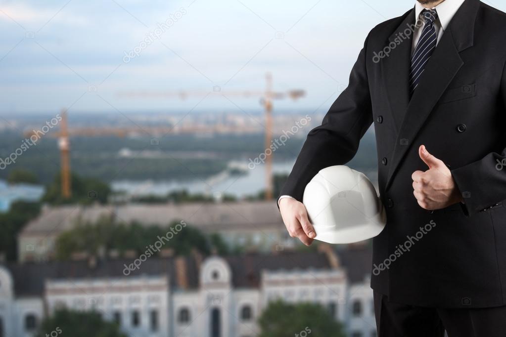 Close up of engineer hand holding white safety helmet for worker