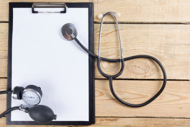 İşyeri bir doktor. Tablet, stetoskop, ahşap Resepsiyon arka plan üzerinde siyah kalem. Üstten Görünüm