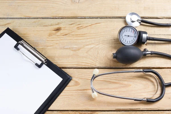 Workplace of a doctor. Tablet, stethoscope, black pen on wooden desk background. Top view — Stock Photo, Image